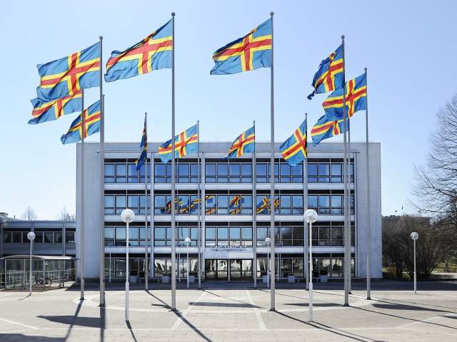 Hissade ålandsflaggor framför lagtingsbyggnaden